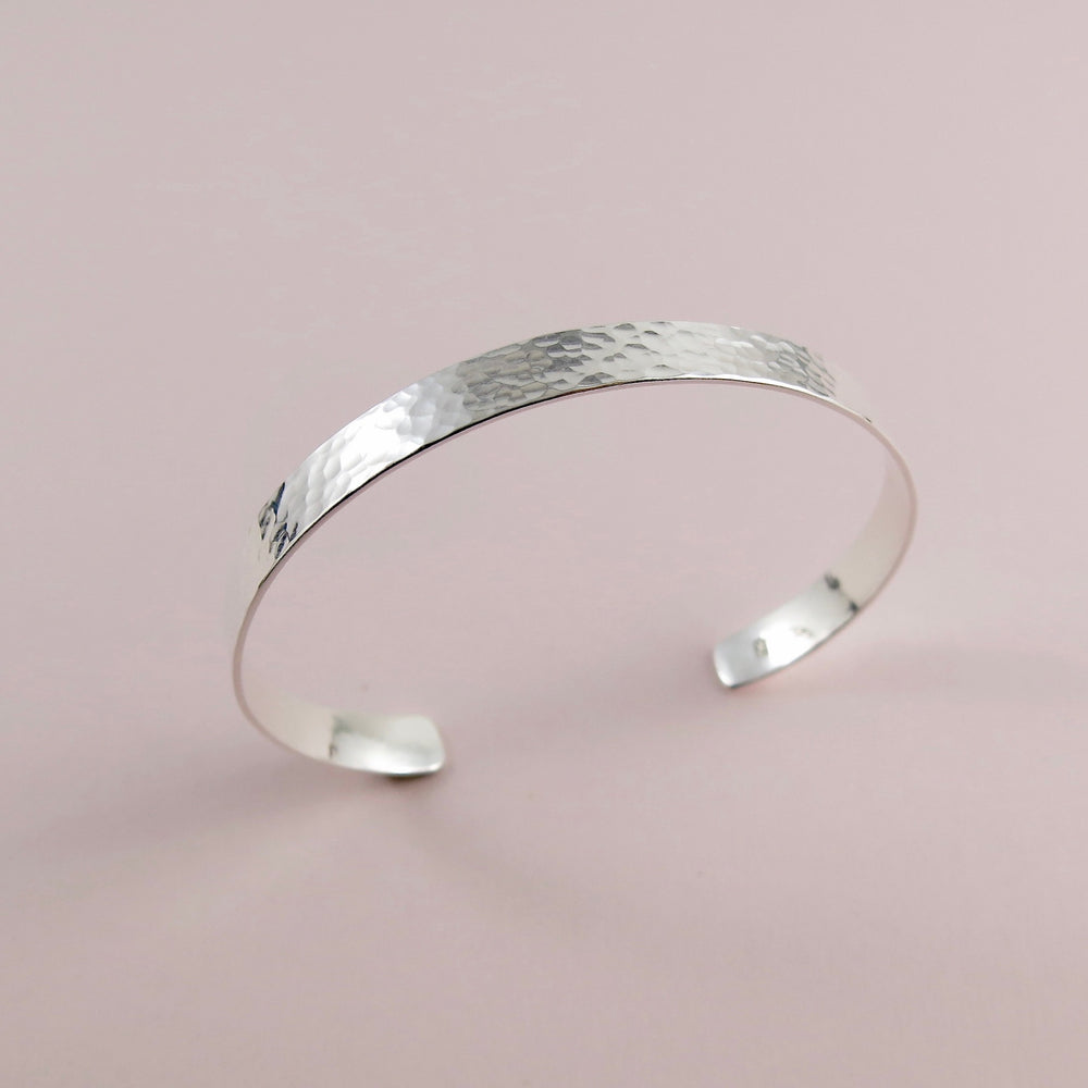 Narrow convex cuff bracelet in hammer textured sterling silver by Mikel Grant Jewellery