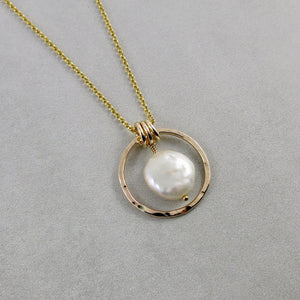 Gold coin pearl necklace by Mikel Grant Jewellery. Lustrous white freshwater coin pearl suspended within a hammer textured gold filled circle.