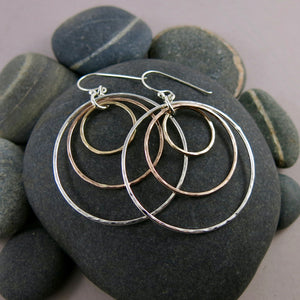 Mixed metal nesting trio circle earrings by Mikel Grant Jewellery. Artisan made hammer textured dangle earrings in silver and gold.