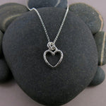 Open heart necklace in sterling silver by Mikel Grant Jewellery.  Artisan made hammer textured open heart charm necklace.