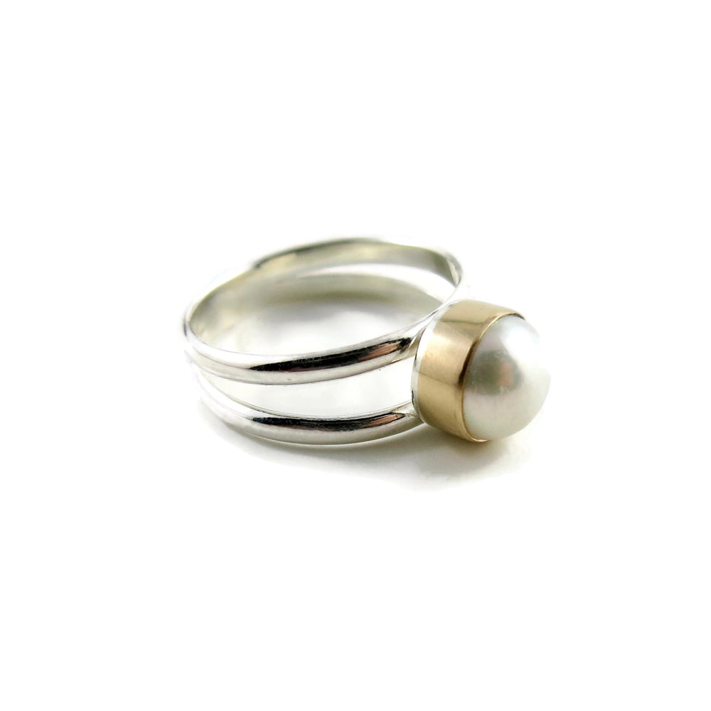 Silver and Gold Split Shank Pearl Ring by Mikel Grant Jewellery. White freshwater button pearl bezel set in 14K gold on a sterling silver split shank band.