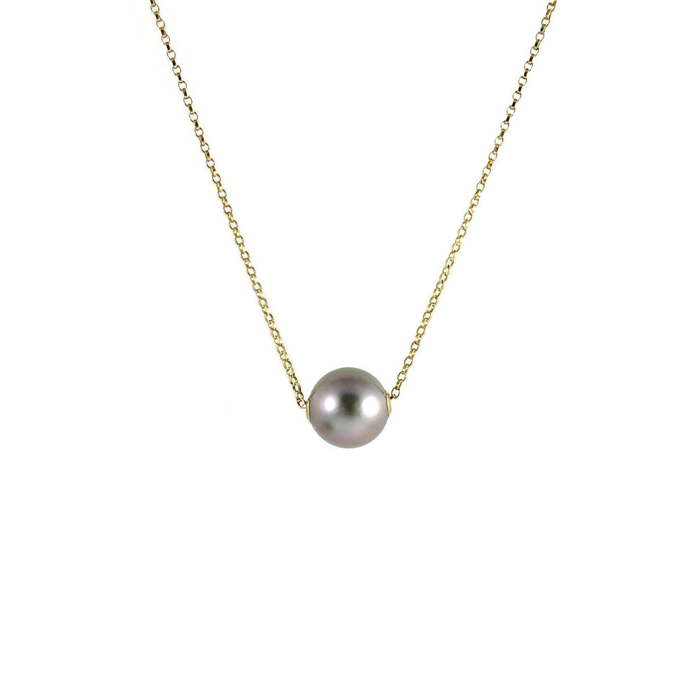 A pearl necklace is displayed on a white background.  The round, gray pearl is suspended on a yellow gold filled rolo chain that slides through the centre of the pearl.