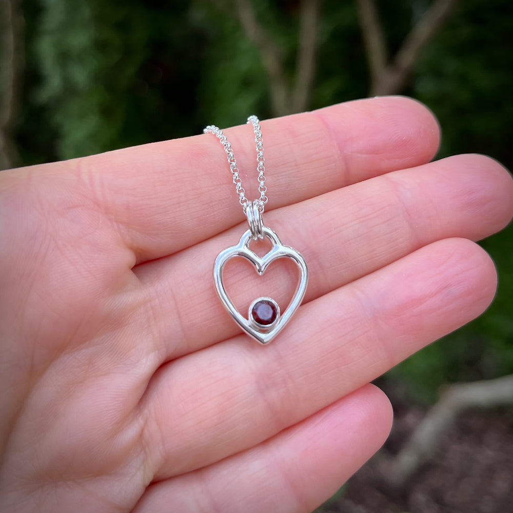 Silver heart pendant with a faceted garnet by Mikel Grant Jewellery