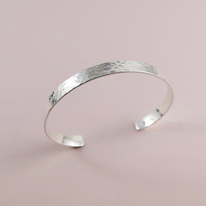 Narrow convex cuff bracelet in hammer textured sterling silver by Mikel Grant Jewellery