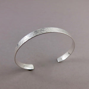 Narrow convex cuff bracelet in hammer textured sterling silver by Mikel Grant Jewellery