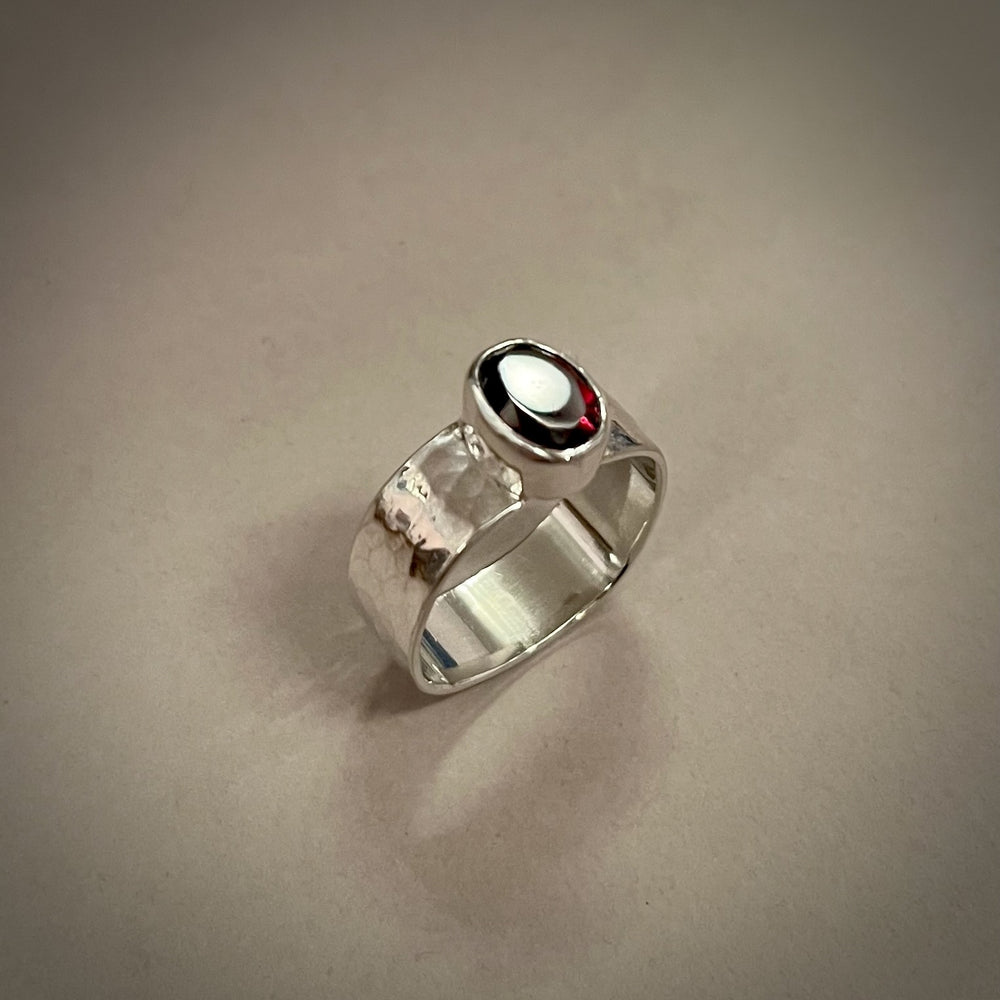 Faceted oval garnet ring on a sterling silver square band ring by Mikel Grant Jewellery