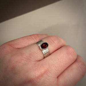 Faceted oval garnet ring on a sterling silver square band ring by Mikel Grant Jewellery