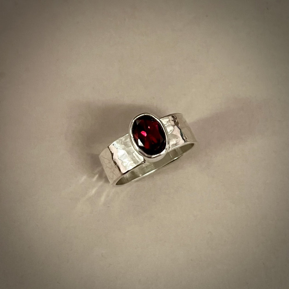 Faceted oval garnet ring on a sterling silver square band ring by Mikel Grant Jewellery