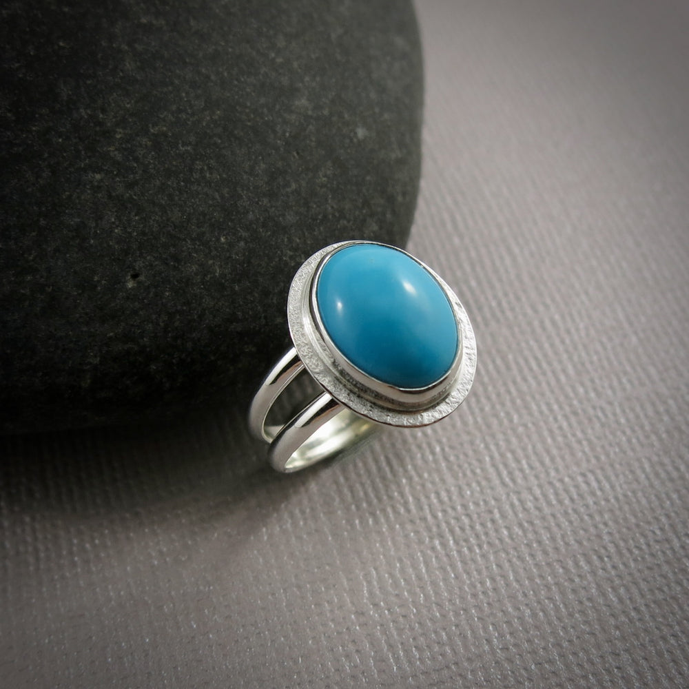 Oval Kingman turquoise halo ring in a sterling silver split-shank ring by Mikel Grant Jewellery.  Size 7.