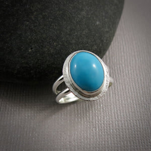 Oval Kingman turquoise halo ring in a sterling silver split-shank ring by Mikel Grant Jewellery.  Size 7.