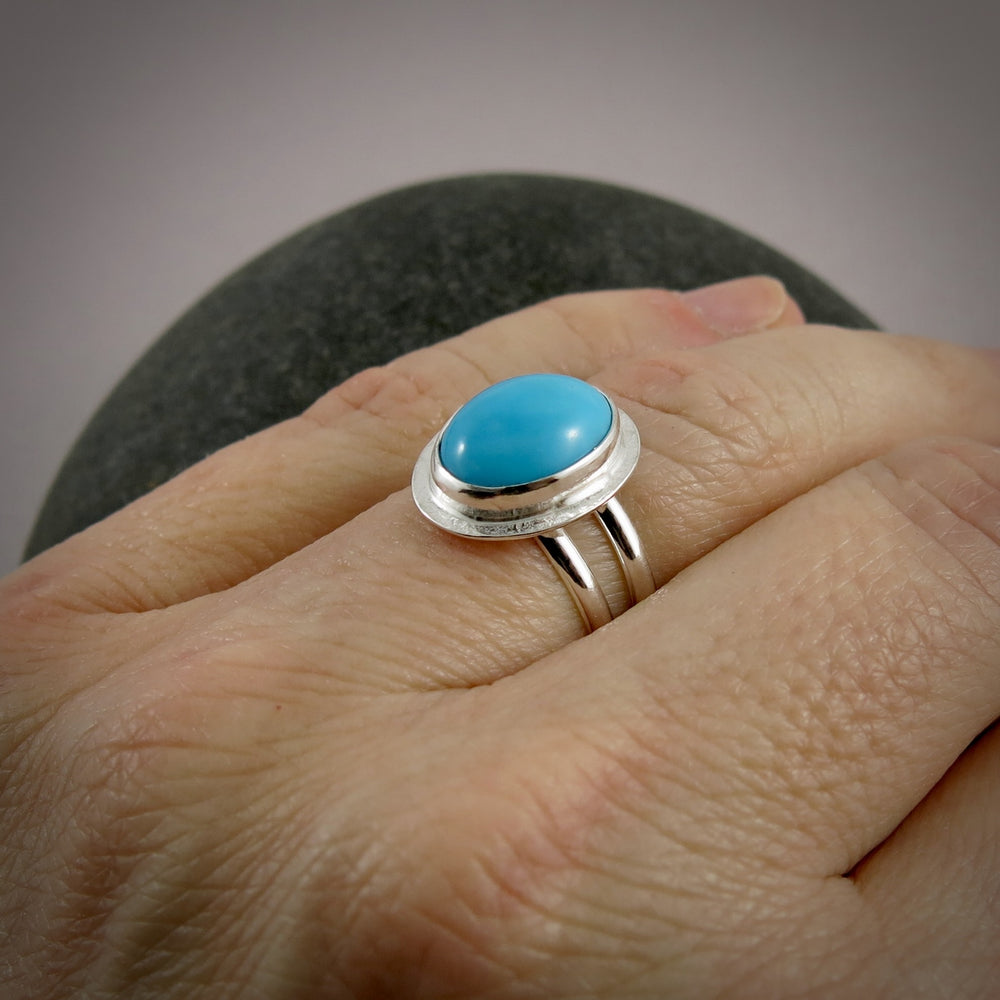 Oval Kingman turquoise halo ring in a sterling silver split-shank ring by Mikel Grant Jewellery.  Size 7.