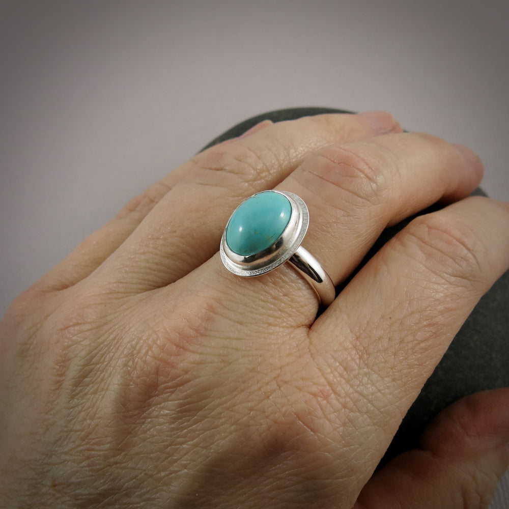 Oval turquoise halo ring in sterling silver by Mikel Grant Jewellery.  Size 9.