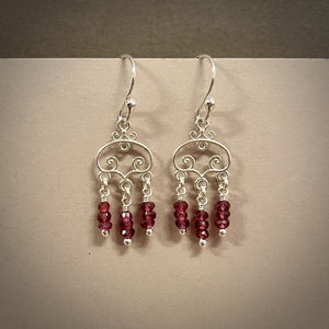 Silver scroll earrings with faceted rhodolite garnet bead drops by Mikel Grant Jewellery