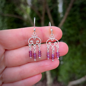 Silver scroll earrings with faceted rhodolite garnet bead drops by Mikel Grant Jewellery