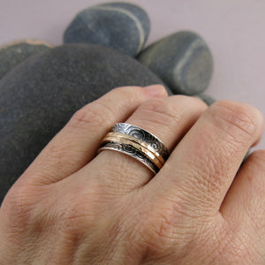 Spirals meditation ring in oxidized sterling silver with gold spinning bands by Mikel Grant Jewellery