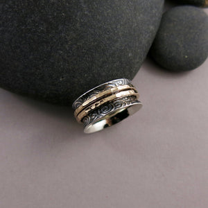 Spirals meditation ring in oxidized sterling silver with gold spinning bands by Mikel Grant Jewellery