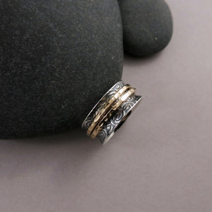 Spirals meditation ring in oxidized sterling silver with gold spinning bands by Mikel Grant Jewellery