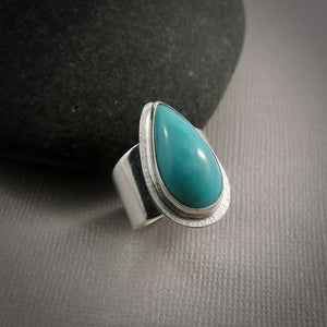 Turquoise talon on a wide silver saddle ring band by Mikel Grant Jewellery.  Size 7.5