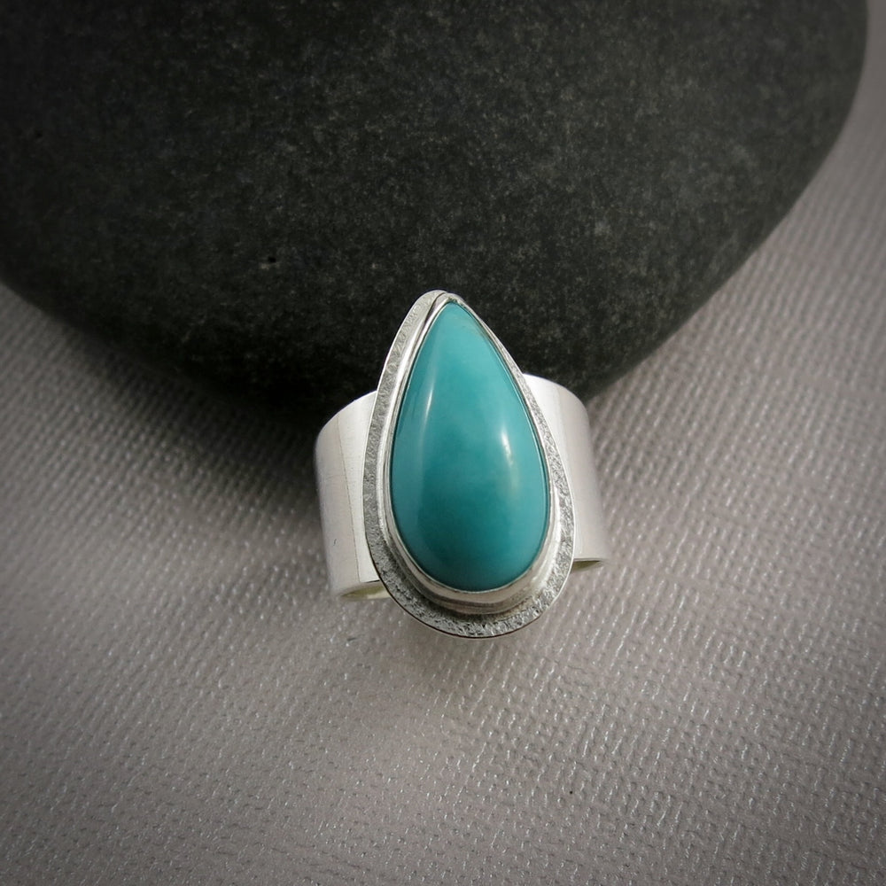 Turquoise talon on a wide silver saddle ring band by Mikel Grant Jewellery.  Size 7.5