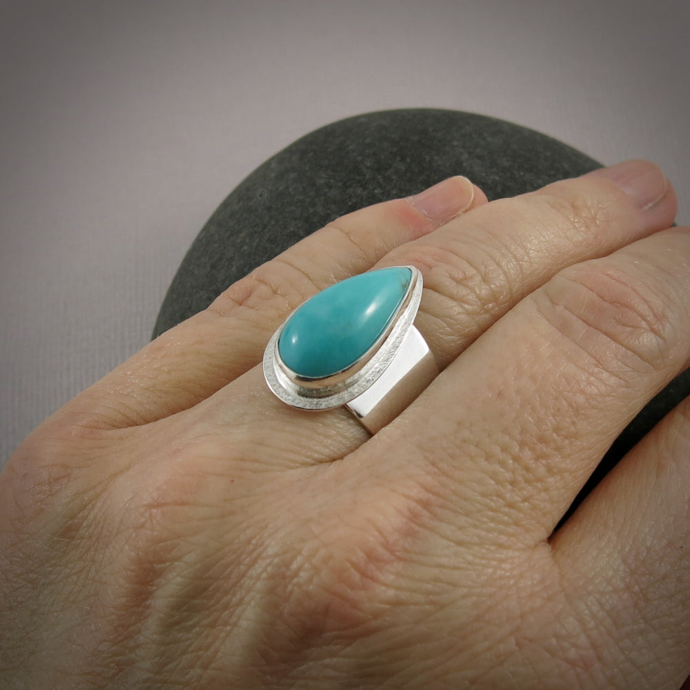 Turquoise talon on a wide silver saddle ring band by Mikel Grant Jewellery.  Size 7.5