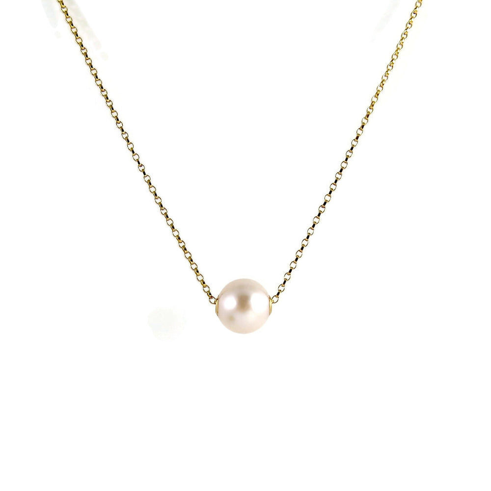 A single pearl necklace on a gold chain is displayed on a white background.  The round white pearl can slide back and forth on the flat gold rolo chain that goes through the middle of the pearl.