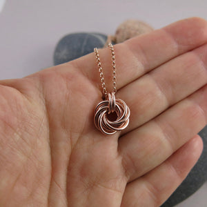 Algerian love knot necklace in 14K rose gold fill by Mikel Grant Jewellery.  Displayed on a hand.