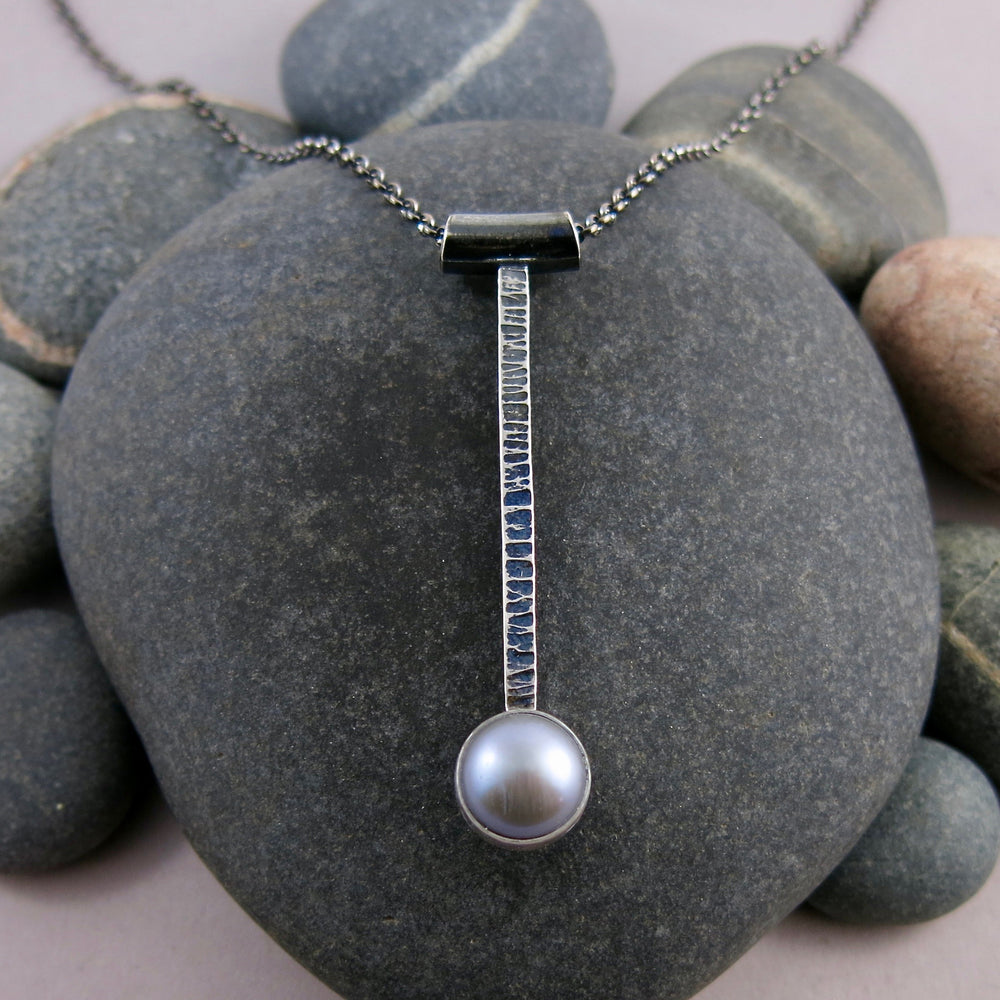 Pearl pendulum necklace by Mikel Grant Jewellery. Grey freshwater pearl on textured and oxidized sterling silver bar.