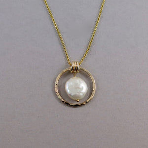 Gold coin pearl necklace by Mikel Grant Jewellery. Lustrous white freshwater coin pearl suspended within a hammer textured gold filled circle.