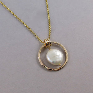 Gold coin pearl necklace by Mikel Grant Jewellery. Lustrous white freshwater coin pearl suspended within a hammer textured gold filled circle.