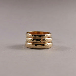 Stack of 14K gold steadfast rings in narrow, medium & wide widths by Mikel Grant Jewellery.