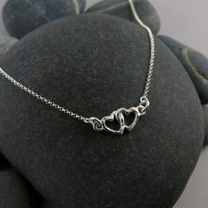 Hearts embrace necklace in sterling silver by Mikel Grant Jewellery.