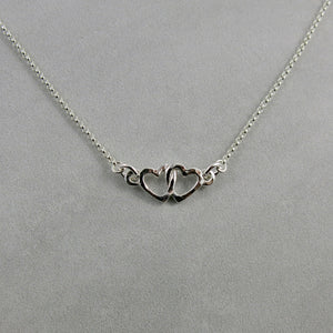 Hearts embrace necklace in sterling silver by Mikel Grant Jewellery.