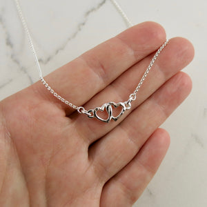 Hearts embrace necklace in sterling silver by Mikel Grant Jewellery.