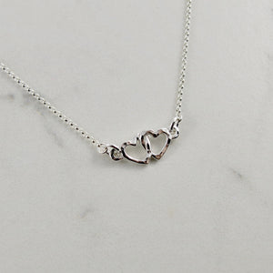 Hearts embrace necklace in sterling silver by Mikel Grant Jewellery.