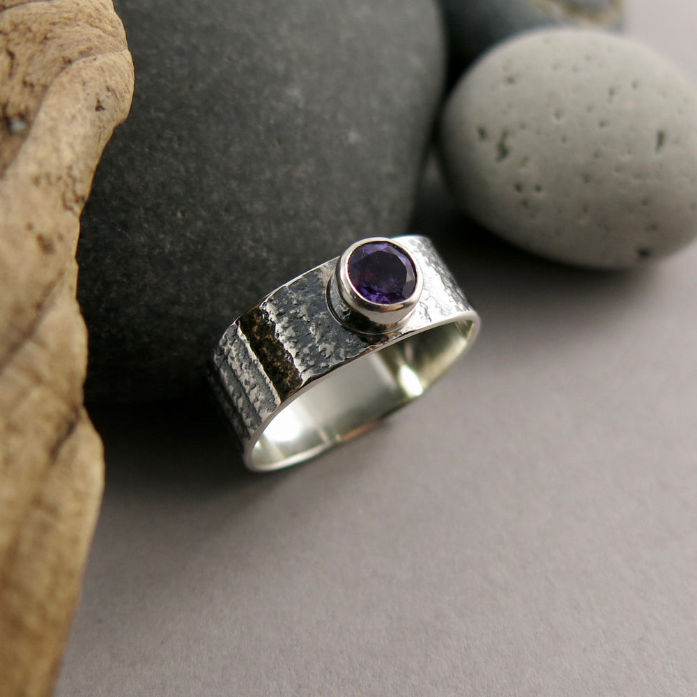 Artisan made jewel drop gemstone ring by Mikel Grant Jewellery. Round faceted amethsyt on a soft square sterling silver band with oxidized tabby striped design.