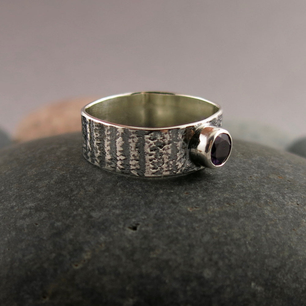Artisan made jewel drop gemstone ring by Mikel Grant Jewellery. Round faceted amethsyt on a soft square sterling silver band with oxidized tabby striped design.