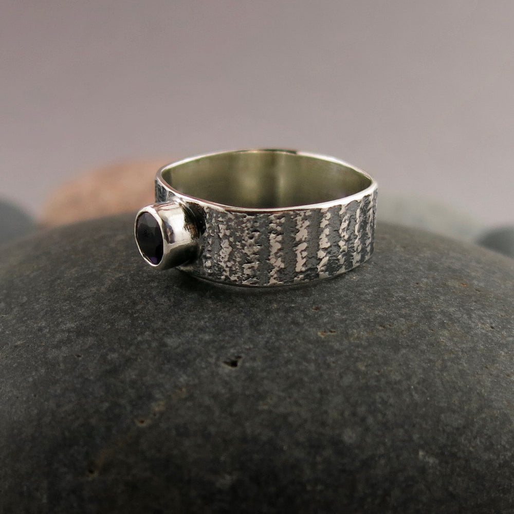 Artisan made jewel drop gemstone ring by Mikel Grant Jewellery. Round faceted amethsyt on a soft square sterling silver band with oxidized tabby striped design.