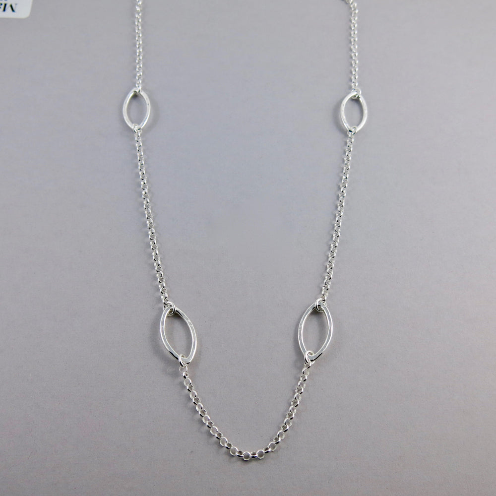 Modern minimalist long sterling silver leaf necklace by Mikel Grant Jewellery. 30" long nature inspired station chain necklace.