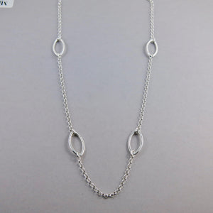 Modern minimalist long sterling silver leaf necklace by Mikel Grant Jewellery. 30" long nature inspired station chain necklace.