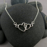 Mother daughter hearts embrace necklace in sterling silver by Mikel Grant Jewellery.