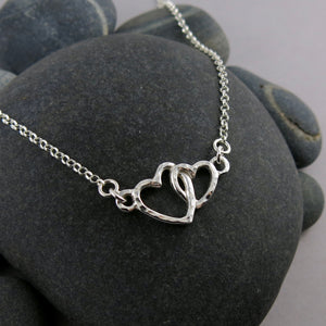 Mother daughter hearts embrace necklace in sterling silver by Mikel Grant Jewellery.