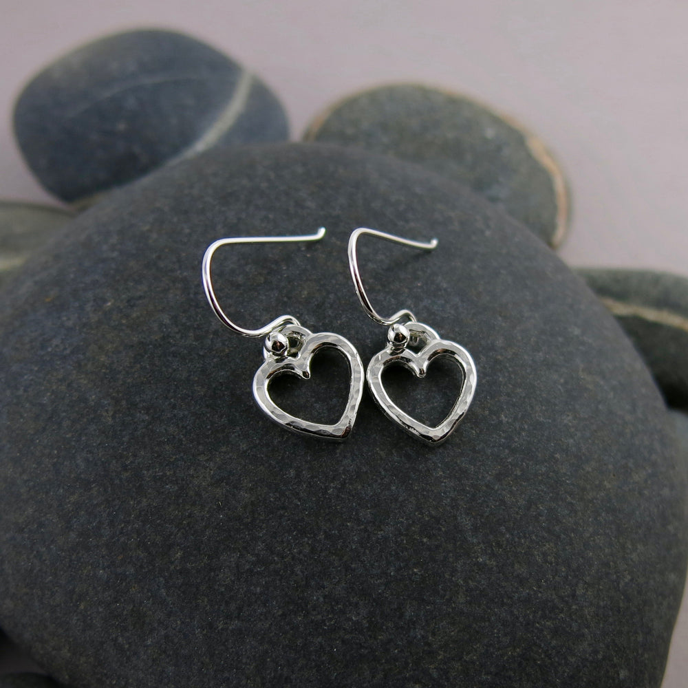 Open heart dangle earrings in sterling silver by Mikel Grant Jewellery. Artisan made hammer textured dangles.