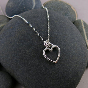 Open heart necklace in sterling silver by Mikel Grant Jewellery. Artisan made hammer textured open heart charm necklace.