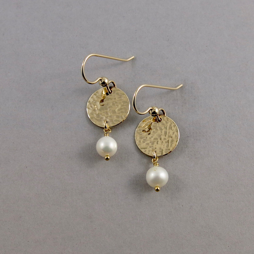 Pearl moondrop earrings in gold by Mikel Grant Jewellery. White freshwater pearls suspended from hammer textured gold filled discs.