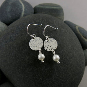 Pearl moondrop earrings by Mikel Grant Jewellery. White freshwater pearls dangle from hand textured sterling silver discs.