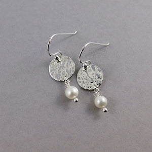 Pearl moondrop earrings by Mikel Grant Jewellery. White freshwater pearls dangle from hand textured sterling silver discs.