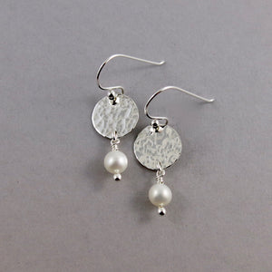 Pearl moondrop earrings by Mikel Grant Jewellery. White freshwater pearls dangle from hand textured sterling silver discs.
