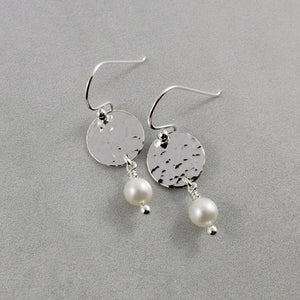 Pearl moondrop earrings by Mikel Grant Jewellery. White freshwater pearls dangle from hand textured sterling silver discs.