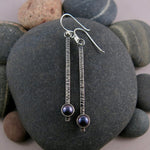Pearl pendulum earrings by Mikel Grant Jewellery. Black freshwater pearls on textured and oxidized sterling silver bars.