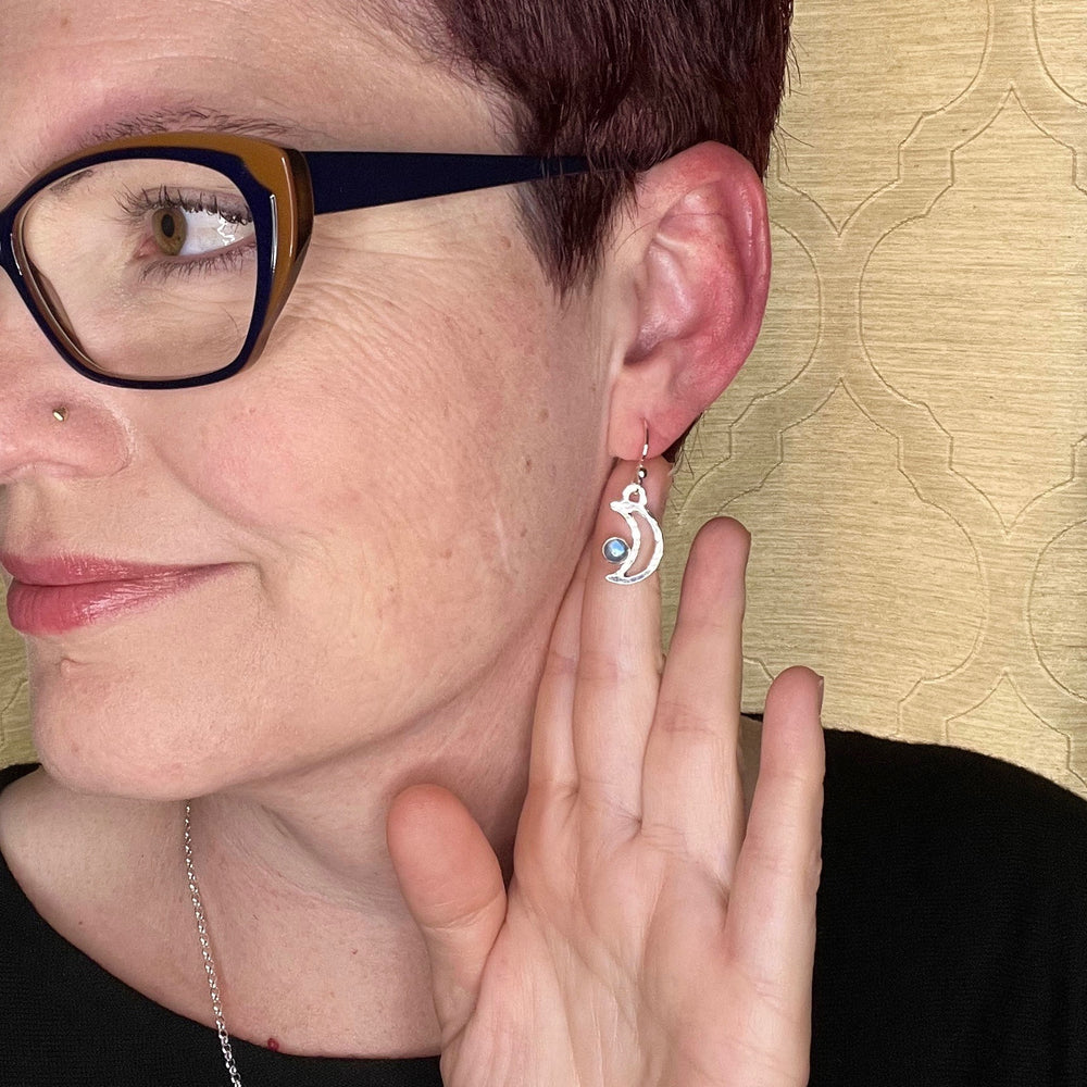 Handcrafted silver crescent moon dangle earrings with rainbow moonstones by Mikel Grant Jewellery.